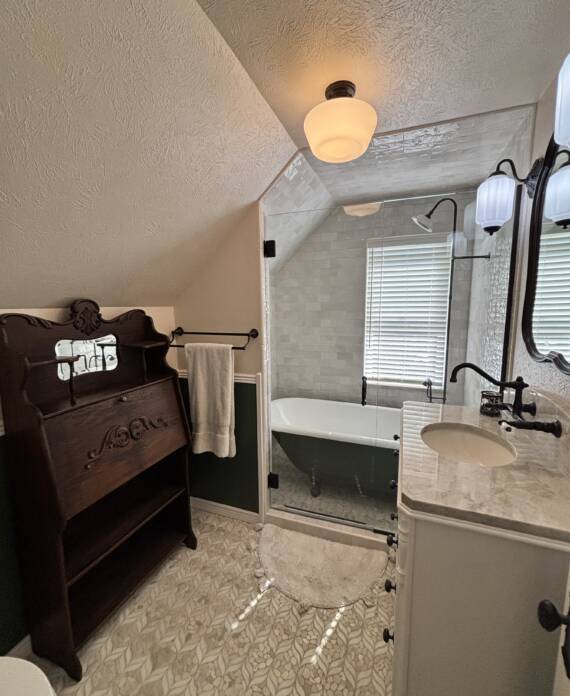 Vintage bathroom remodel with furniture vanity and clawfoot tub in Colorado Springs