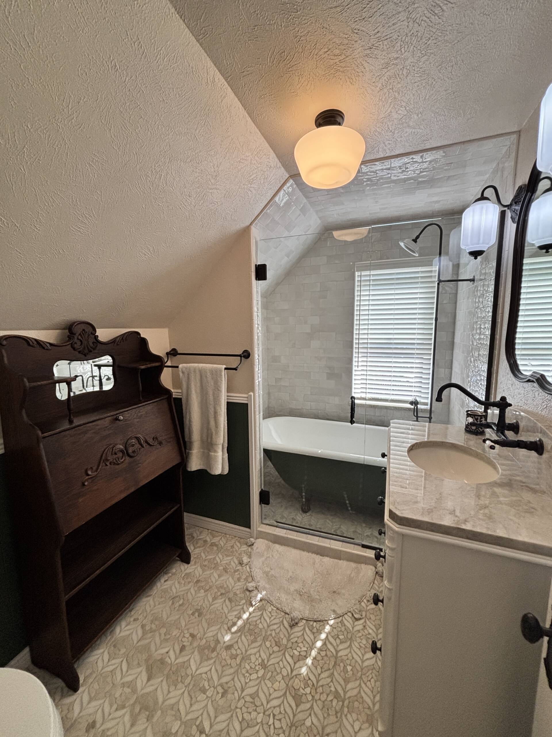Vintage bathroom remodel with furniture vanity and clawfoot tub in Colorado Springs