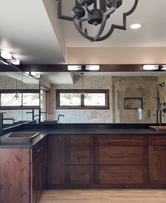 Primary bathroom remodel with dark wood vanity and black fixtures in Colorado Springs